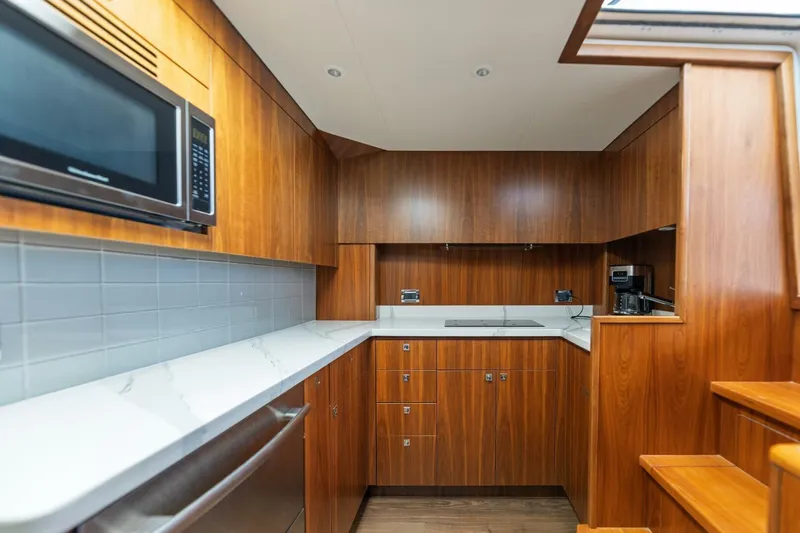 Reely Yacht Photos Pics Luxurious 2018 Hatteras GT45X Flybridge yacht kitchen with wood cabinetry and modern appliances.