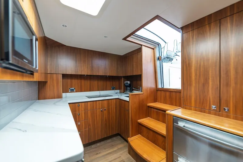 Reely Yacht Photos Pics Luxurious wood-finished kitchen in 2018 Hatteras GT45X Flybridge yacht, featuring modern appliances.
