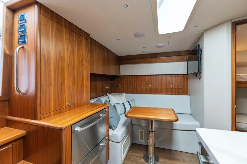Reely Yacht Photos Pics 2018 Hatteras GT45X Flybridge interior with wood cabinetry, dining area, and modern amenities.