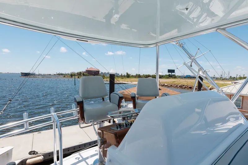 Reely Yacht Photos Pics 2018 Hatteras GT45X Flybridge with helm chairs overlooking marina and waterway.