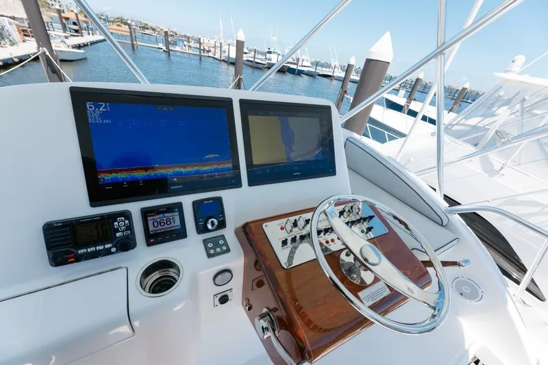 Reely Yacht Photos Pics Flybridge helm of 2018 Hatteras GT45X with navigation screens and controls, docked at marina.
