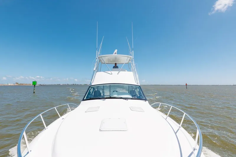 Reely Yacht Photos Pics 2018 Hatteras GT45X Flybridge cruising on open water under clear blue sky.