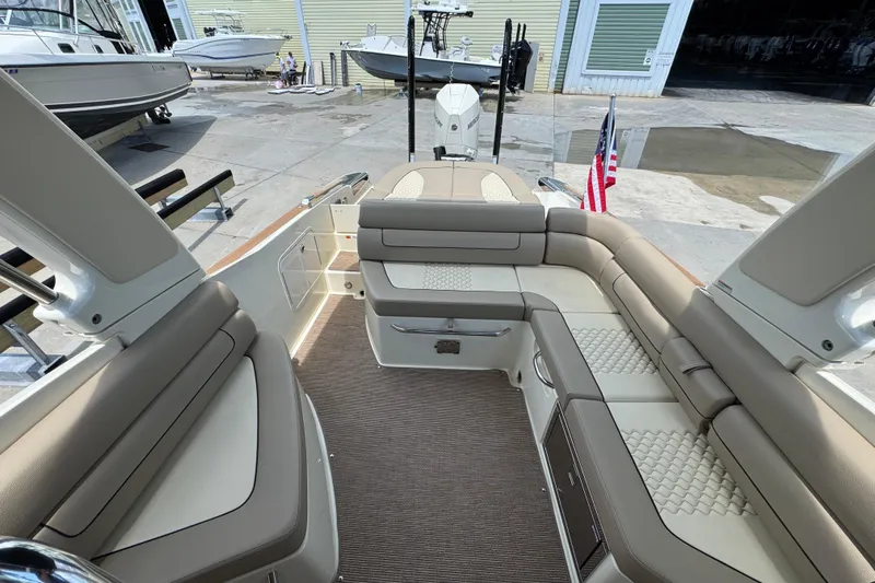  Yacht Photos Pics 2023 Chris-Craft Launch 25 GT boat interior with beige seating and American flag.