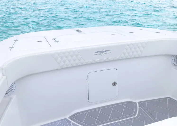  Yacht Photos Pics 2023 Invincible 33 Catamaran deck with ocean backdrop, featuring sleek design and storage compartment.