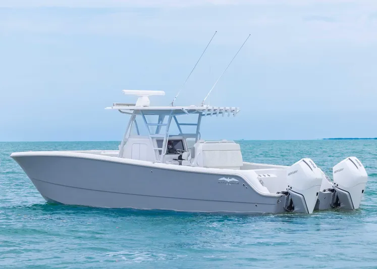  Yacht Photos Pics 2023 Invincible 33 Catamaran on calm ocean waters, featuring dual outboard engines.