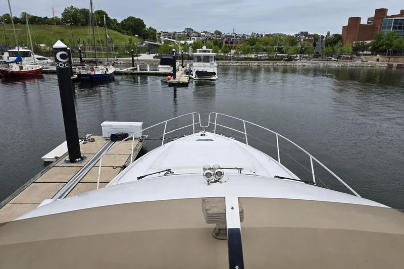  Yacht Photos Pics 1999 Viking Princess 56 yacht docked in a marina with surrounding boats and buildings.