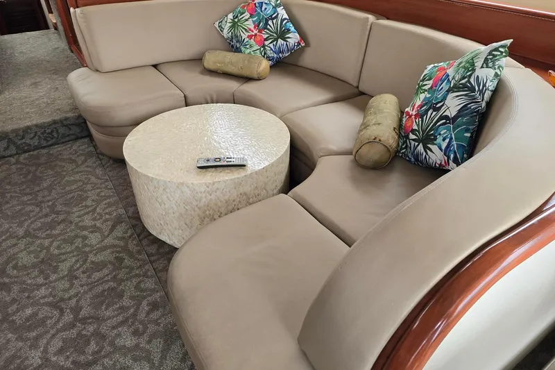  Yacht Photos Pics Luxurious 1999 Viking Princess 56 yacht interior with curved beige sofa and decorative pillows.