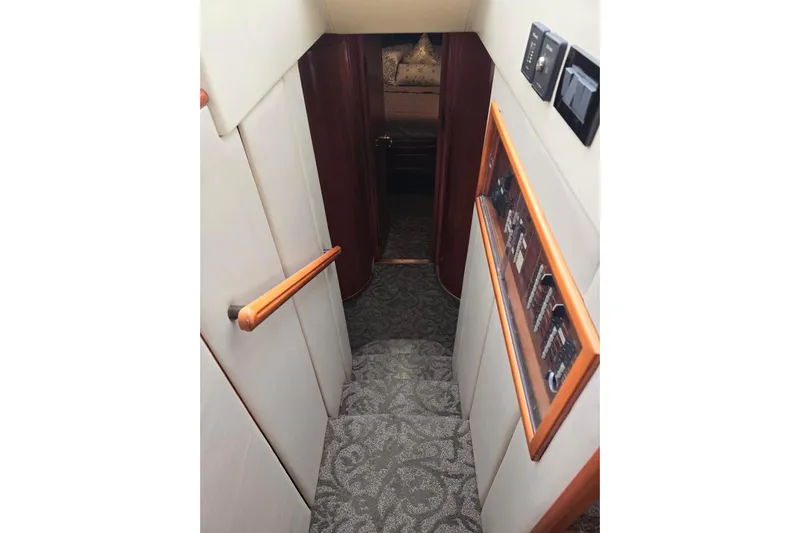 Yacht Photos Pics Staircase inside 1999 Viking Princess 56 yacht, featuring carpeted steps and wooden handrails.