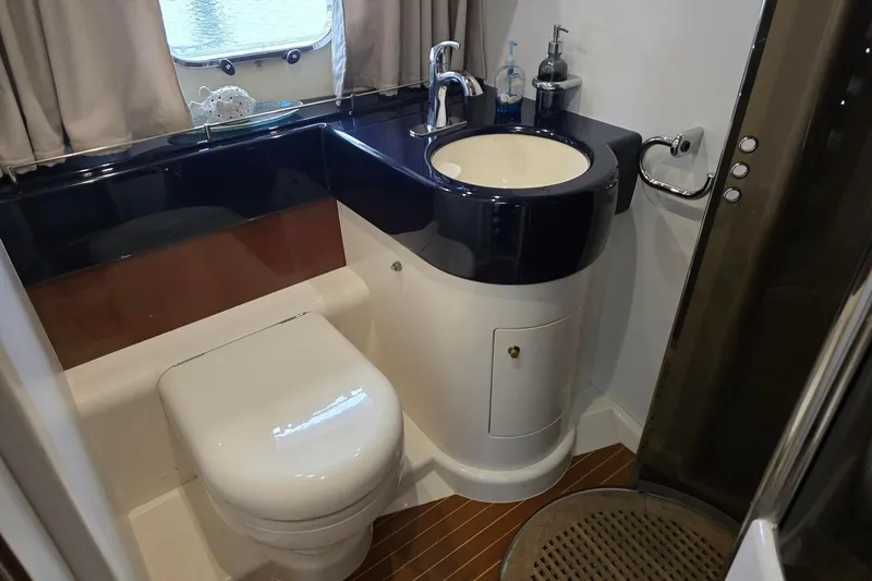  Yacht Photos Pics Bathroom interior of 1999 Viking Princess 56 yacht with modern fixtures and wooden flooring.