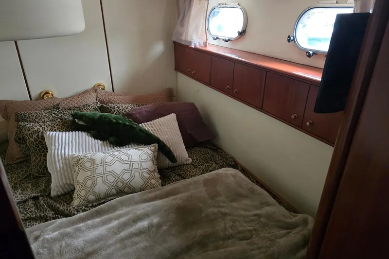  Yacht Photos Pics Luxurious cabin interior of 1999 Viking Princess 56 yacht with plush bedding and porthole windows.