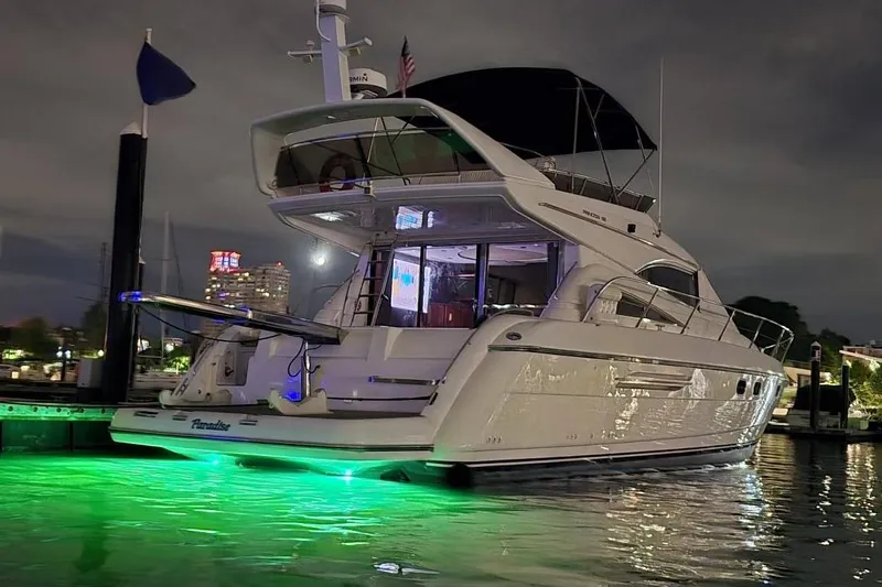  Yacht Photos Pics Luxurious 1999 Viking Princess 56 yacht docked at night with glowing green underwater lights.