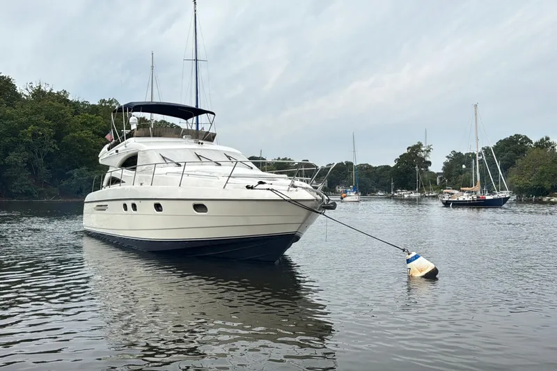  Yacht Photos Pics 1999 Viking Princess 56 yacht moored on a serene lake with surrounding sailboats.