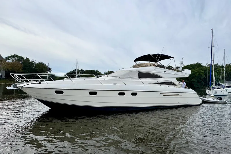  Yacht Photos Pics 1999 Viking Princess 56 yacht on calm water, featuring sleek design and spacious deck.