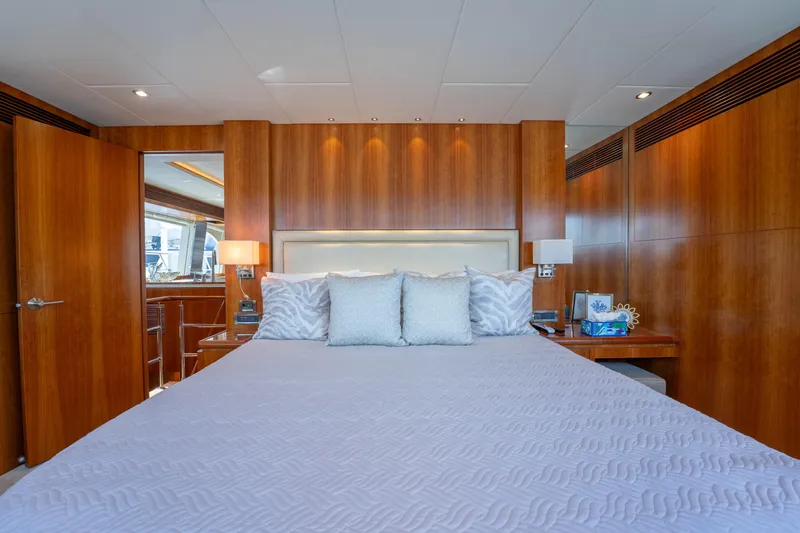 Vitality Yacht Photos Pics Luxurious bedroom interior on 2016 Horizon PC60 yacht with wooden paneling and elegant bedding.
