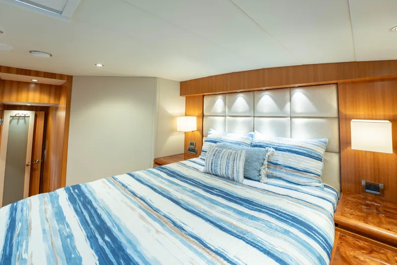 Vitality Yacht Photos Pics Luxurious bedroom interior on 2016 Horizon PC60 yacht with striped bedding and wood accents.
