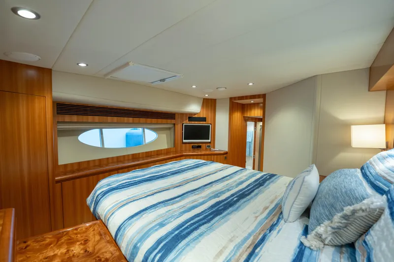 Vitality Yacht Photos Pics Luxurious bedroom interior of 2016 Horizon PC60 yacht with wood paneling and striped bedding.