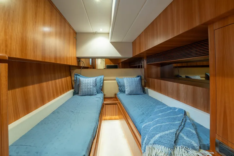 Vitality Yacht Photos Pics Luxurious twin cabin interior on 2016 Horizon PC60 yacht with wooden finish and blue bedding.