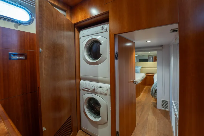 Vitality Yacht Photos Pics Laundry area with stacked washer and dryer in 2016 Horizon PC60 yacht interior.