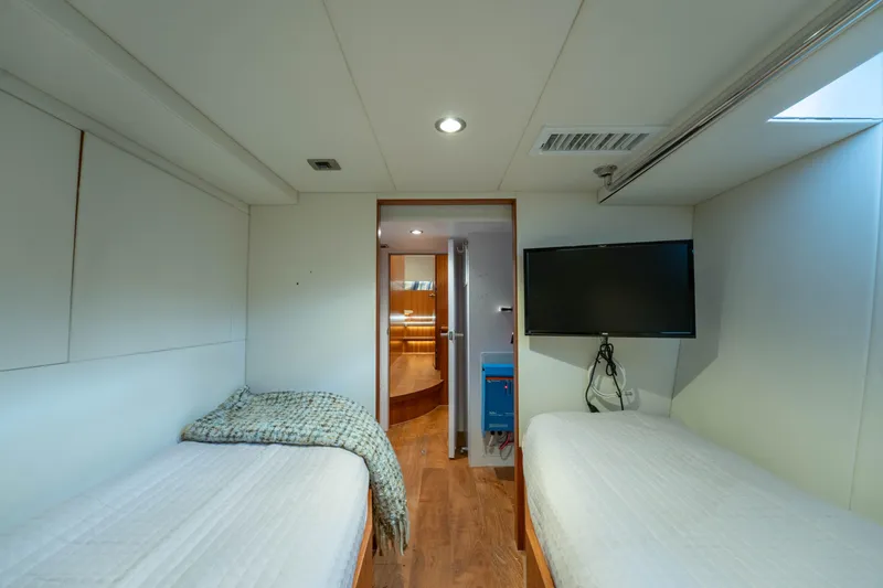 Vitality Yacht Photos Pics Interior of 2016 Horizon PC60 yacht cabin with twin beds and wall-mounted TV.