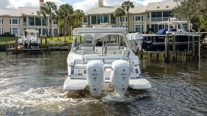  Yacht Photos Pics 2022 Regal LX36 boat with dual engines docked near waterfront homes.