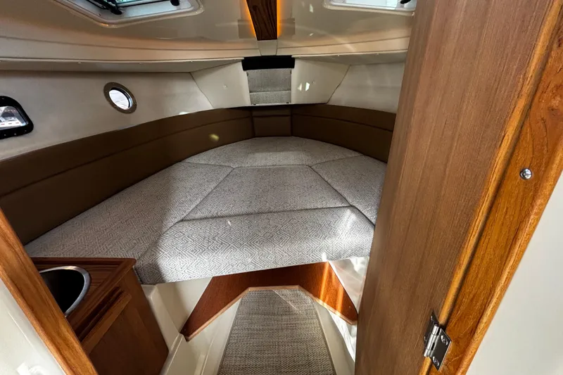  Yacht Photos Pics 2026 Ranger Tugs R-23 cabin interior with cozy bed and wooden accents.