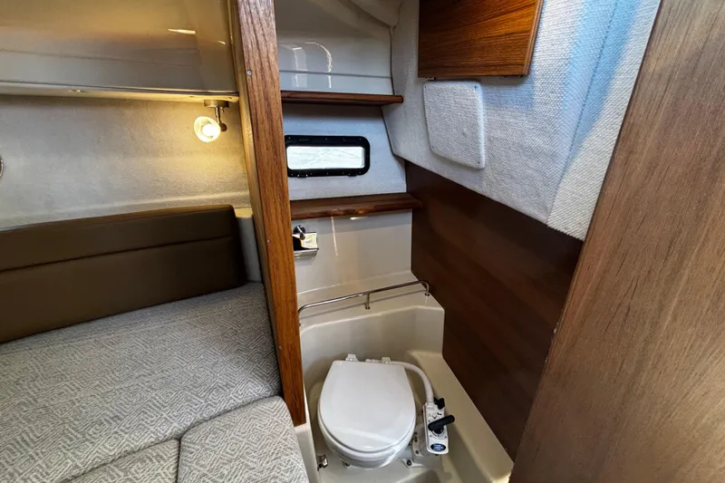  Yacht Photos Pics 2026 Ranger Tugs R-23 interior cabin with compact toilet and cozy seating area.