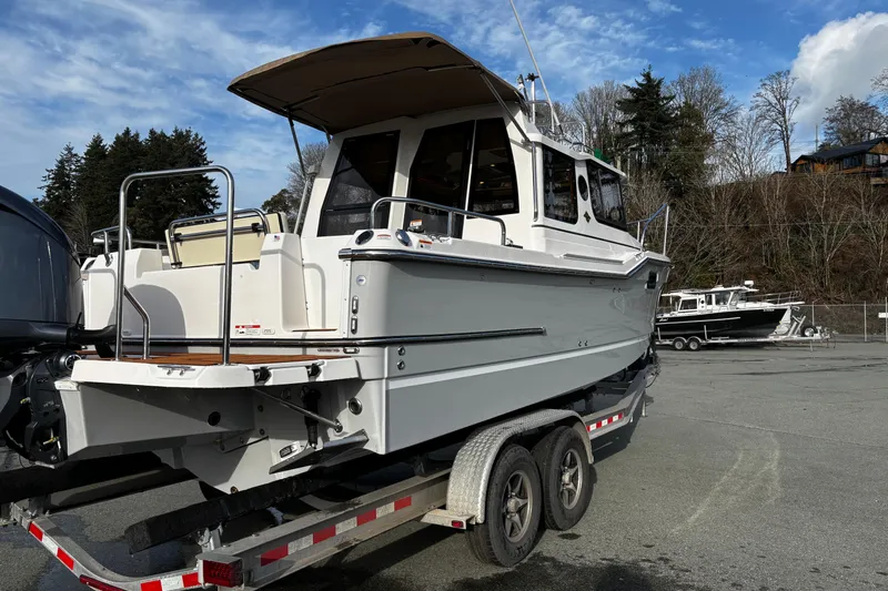  Yacht Photos Pics 2026 Ranger Tugs R-23 boat on trailer, parked outdoors under a blue sky.