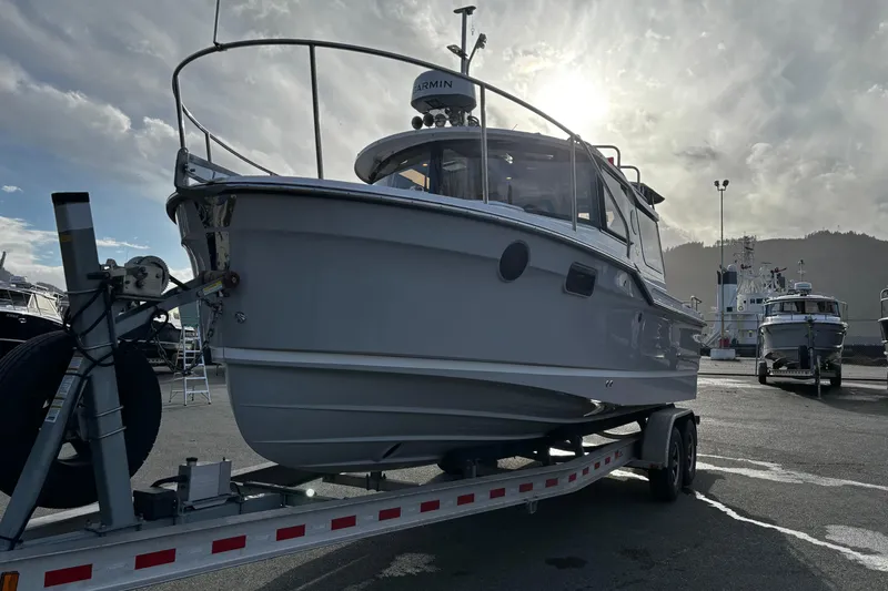  Yacht Photos Pics 2026 Ranger Tugs R-23 boat on trailer, parked in marina under cloudy sky.