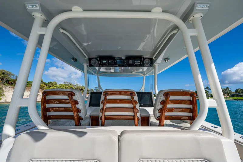 Seas The Day Yacht Photos Pics Interior view of 2020 Jupiter 43 boat with wooden seats and ocean backdrop.