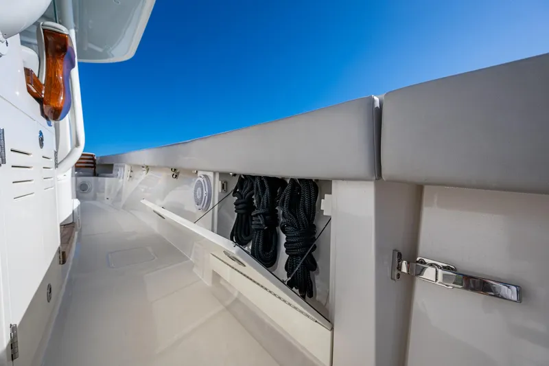 Seas The Day Yacht Photos Pics 2020 Jupiter 43 boat deck with storage compartments and coiled ropes under a clear blue sky.
