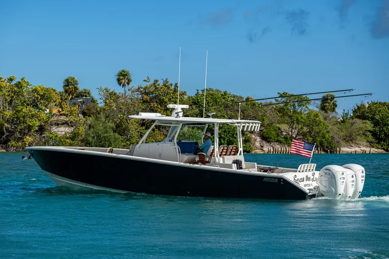 Seas The Day Yacht Photos Pics 2020 Jupiter 43 boat cruising on blue water with trees in the background.