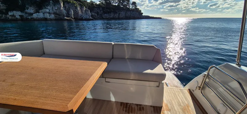 Good Spirit Yacht Photos Pics 2024 Prestige 460S yacht deck with seating, wooden table, and scenic ocean view.