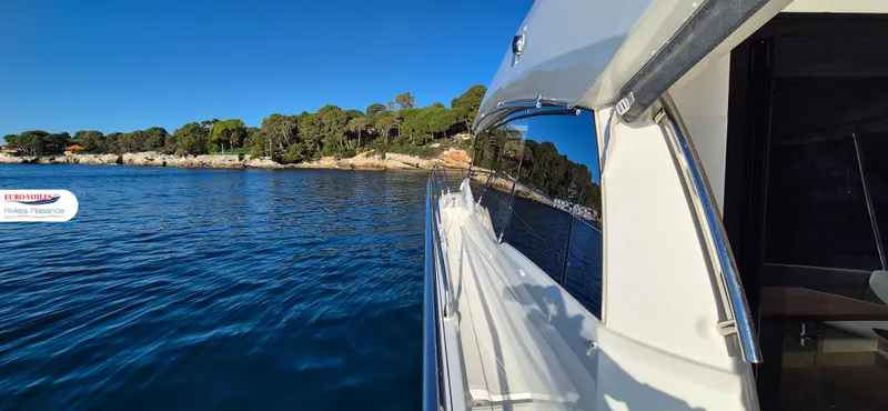 Good Spirit Yacht Photos Pics 2024 Prestige 460S yacht cruising near a scenic coastline under clear blue skies.