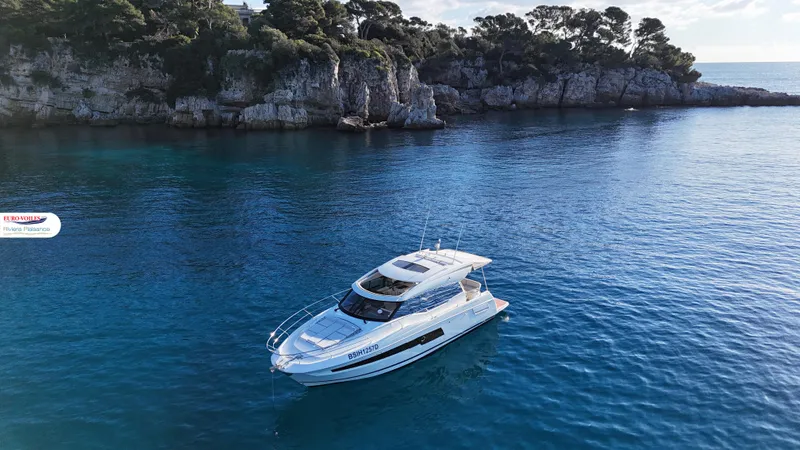 Good Spirit Yacht Photos Pics 2024 Prestige 460S yacht cruising in clear blue waters near rocky coastline.