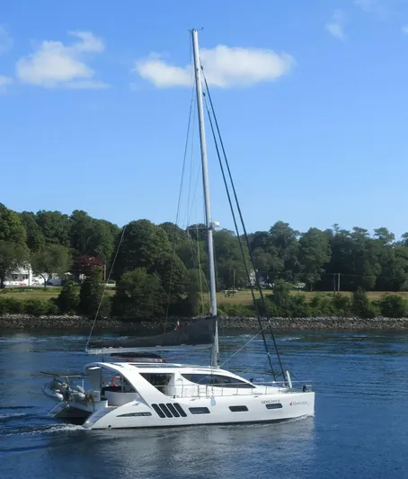  Yacht Photos Pics 2019 Xquisite Yachts X5 sailing on a calm river with lush green trees.
