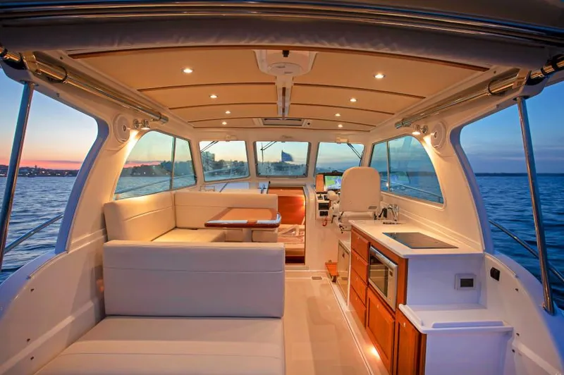 Fifth Child Yacht Photos Pics Manufacturer Provided Image: 2019 Back Cove 34O yacht interior with sunset view, modern seating, and kitchenette.