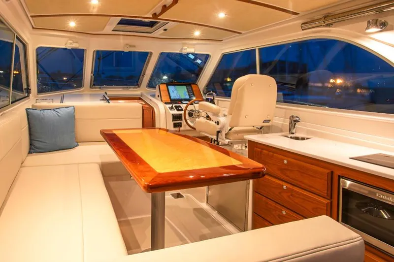 Fifth Child Yacht Photos Pics Manufacturer Provided Image: Interior of 2019 Back Cove 34O yacht with helm, seating, and dining table.