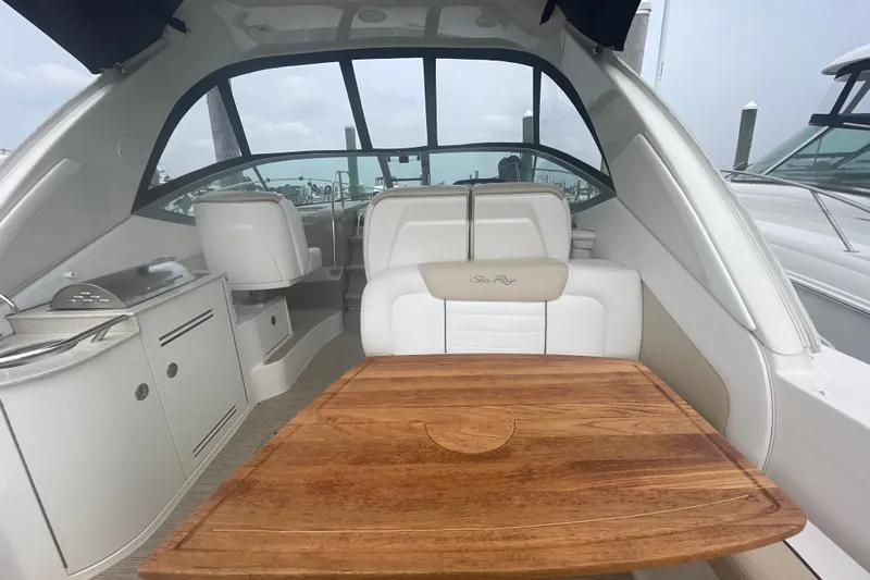 Catalyst Yacht Photos Pics 2009 Sea Ray 330 Sundancer interior with wooden table and white seating.