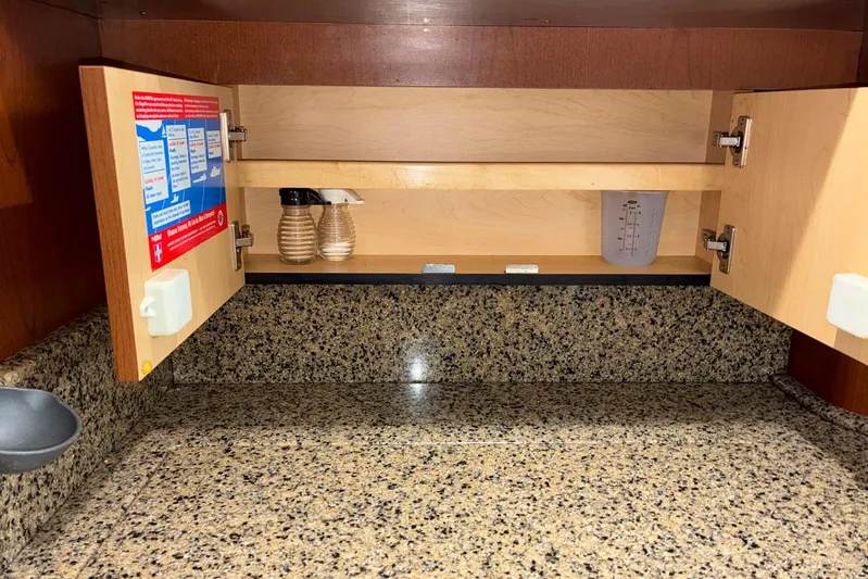 Still Waters Yacht Photos Pics Open cabinet on 2007 Sea Ray 44 Sedan Bridge with granite countertop and spice containers.