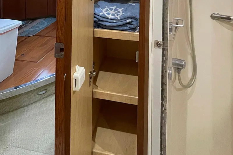 Still Waters Yacht Photos Pics Open cabinet in 2007 Sea Ray 44 Sedan Bridge yacht bathroom, showing shelves and folded towels.