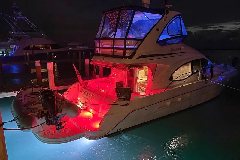Still Waters Yacht Photos Pics 2007 Sea Ray 44 Sedan Bridge yacht illuminated at night with vibrant red and blue lights.