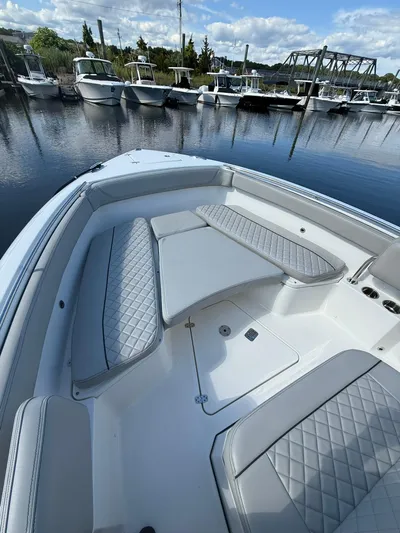  Yacht Photos Pics 2023 Pursuit S 268 Sport boat interior with cushioned seating, docked in a marina.