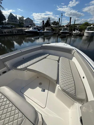  Yacht Photos Pics 2023 Pursuit S 268 Sport boat interior with cushioned seating, docked in a marina.