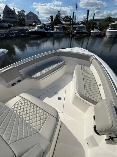  Yacht Photos Pics 2023 Pursuit S 268 Sport boat with luxurious seating at a marina.