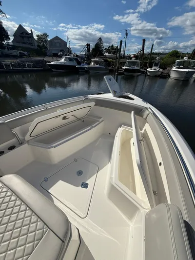  Yacht Photos Pics 2023 Pursuit S 268 Sport boat interior with open storage compartments at a marina.