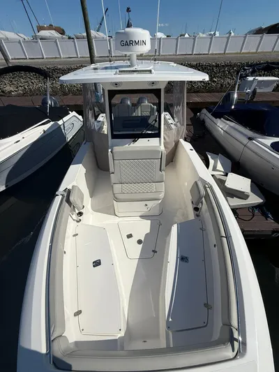  Yacht Photos Pics 2023 Pursuit S 268 Sport boat docked, featuring spacious deck and Garmin equipment.