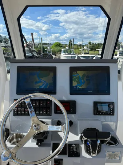  Yacht Photos Pics 2023 Pursuit S 268 Sport boat dashboard with navigation screens and steering wheel.