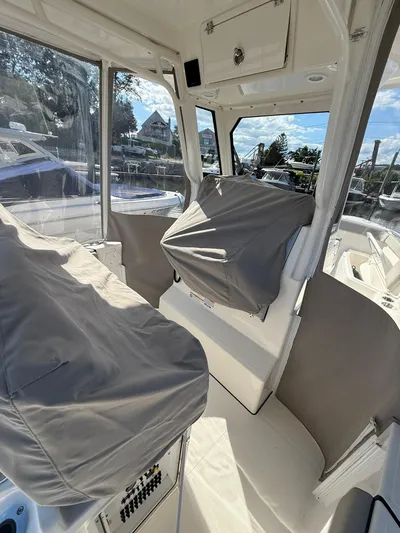  Yacht Photos Pics 2023 Pursuit S 268 Sport boat interior with covered seats and clear windows.