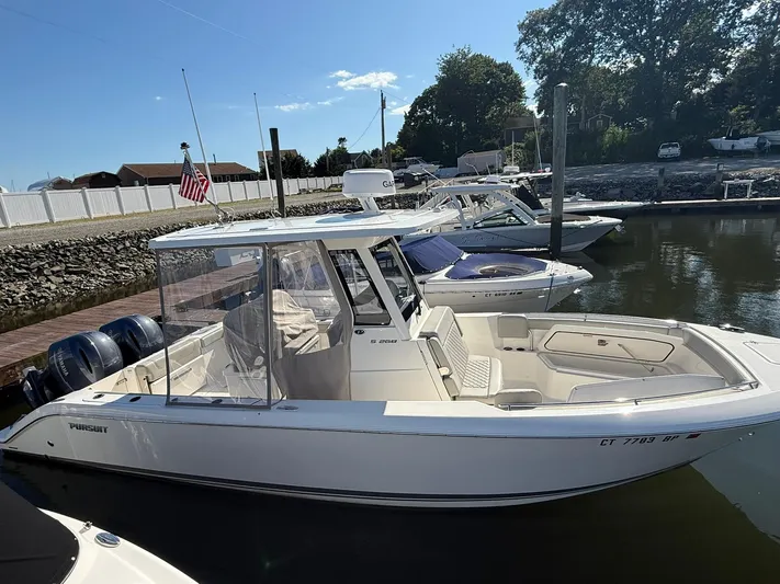  Yacht Photos Pics 2023 Pursuit S 268 Sport boat docked in a marina under clear skies.