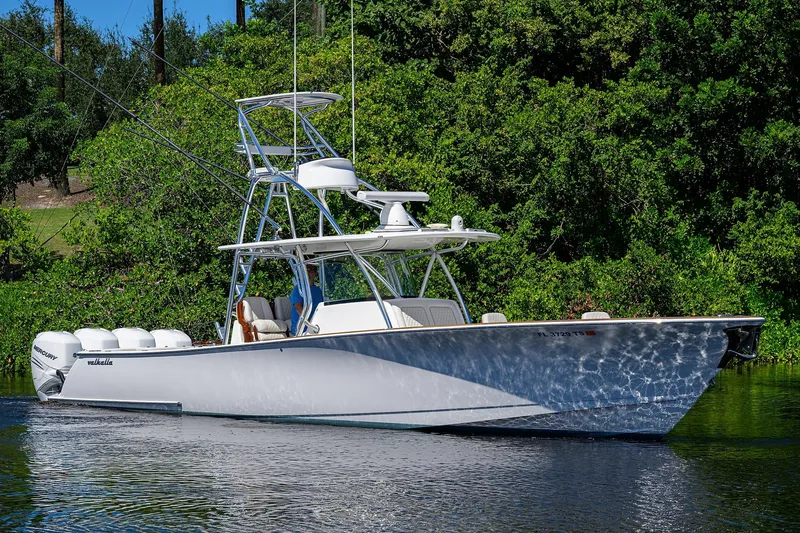 Miss Allied Yacht Photos Pics 2022 Valhalla V41 boat on water, surrounded by lush greenery.